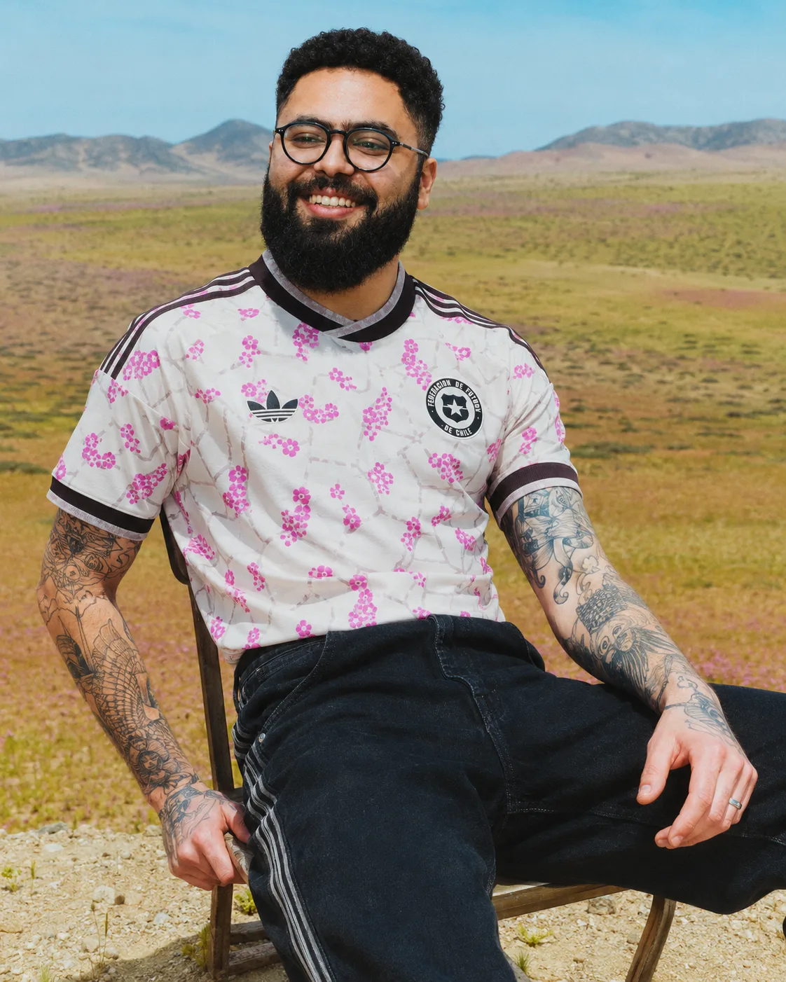 Camiseta visita de Chile 2026 puesta: blanca con flores rosadas, en el desierto florido de Atacama